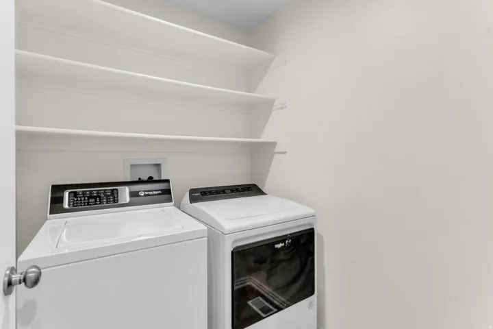 Dedicated laundry area featuring a white top-load washer and a white front-load dryer