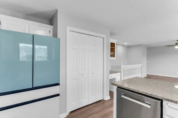 Kitchen featuring white cabinetry, granite countertops, stainless steel appliances, a doubl sink, and wood-finish flooring