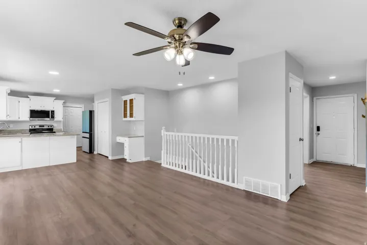 Open-concept living space featuring wood-finish flooring, recessed lighting, and a contemporary ceiling fan