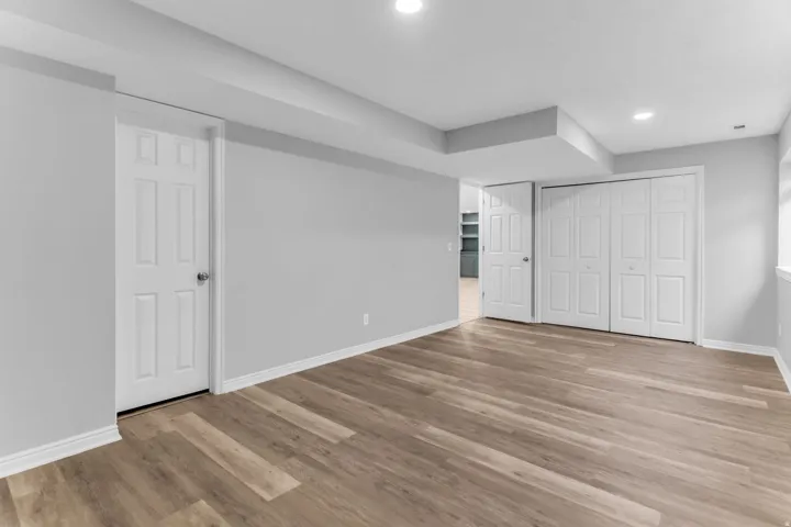 Spacious room featuring wood-finish flooring and light gray walls