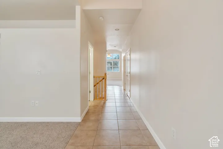 Hallway featuring tiled flooring, recessed lighting, and light-toned wall finishes