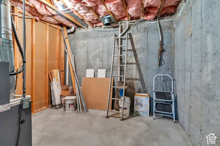 Unfinished basement featuring concrete foundation walls, exposed wood ceiling joists with insulation, concrete flooring, and an exposed HVAC duct system