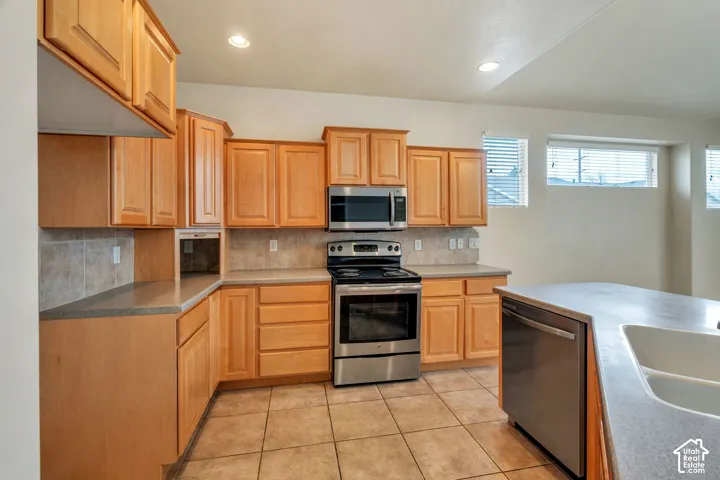 Kitchen featuring a built-in stainless steel microwave, electric range, and dishwasher