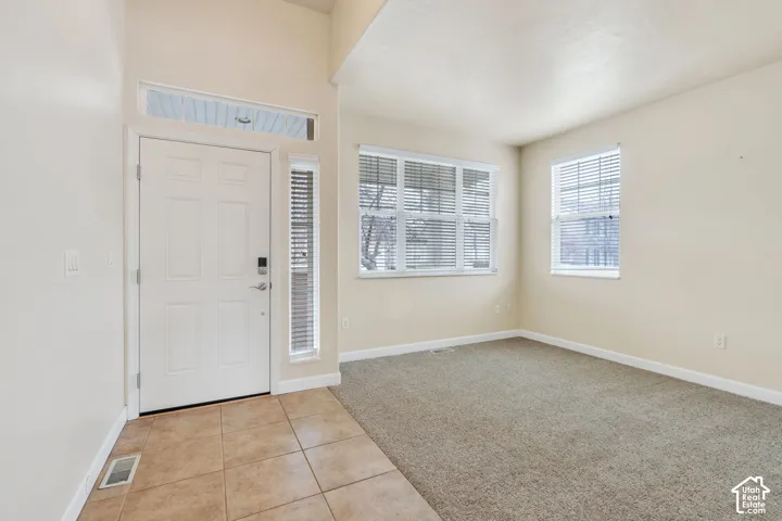 Entryway featuring a paneled door with transom window, side light, and ceramic tile flooring