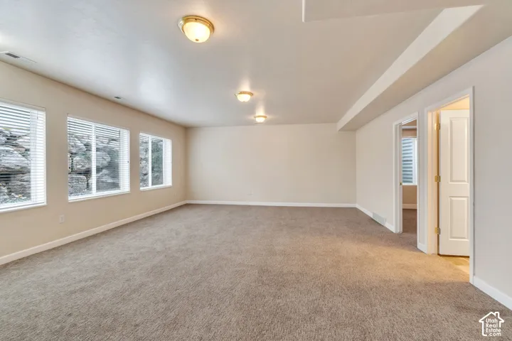 Spacious room featuring neutral carpeting and light beige walls