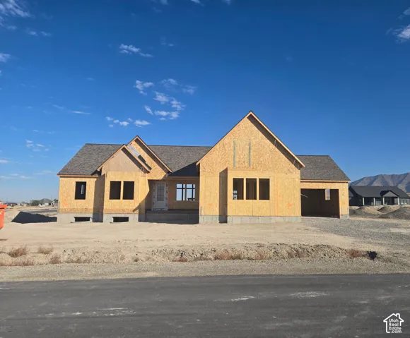 New construction with a prominent front entrance, multiple window openings, and an attached garage structure