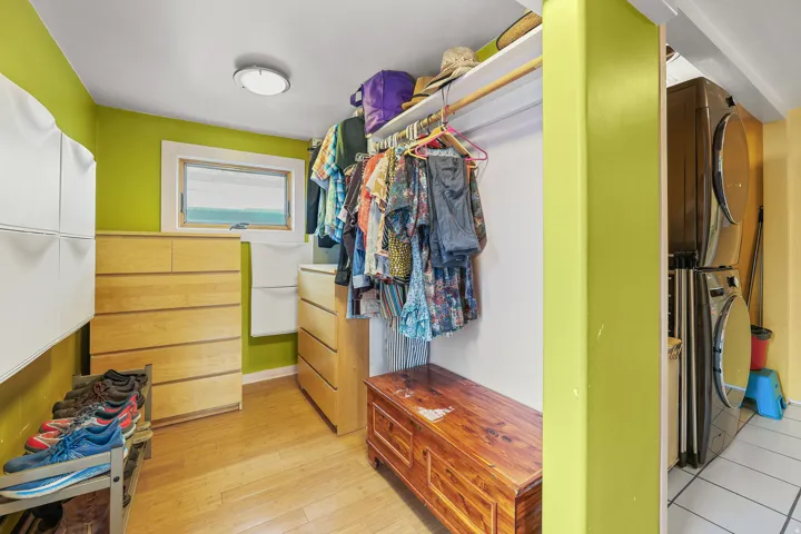 Dedicated laundry area featuring stacked front-load machines and tiled flooring