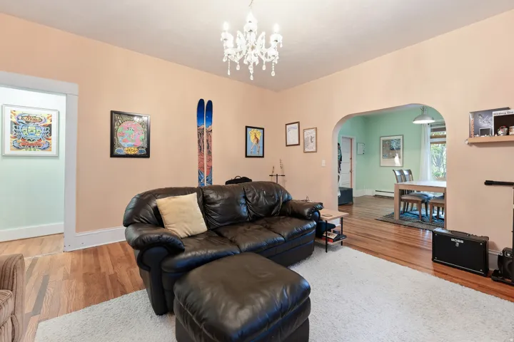 Hardwood flooring extends throughout this space, complemented by a decorative chandelier