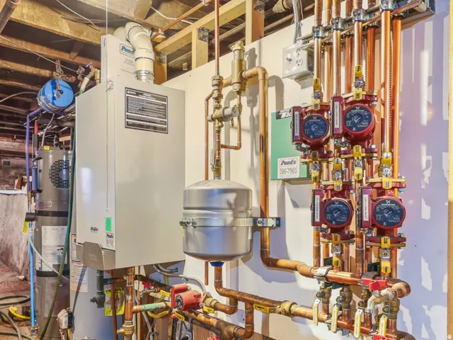 Mechanical room featuring a water heater, boiler system, and extensive copper piping