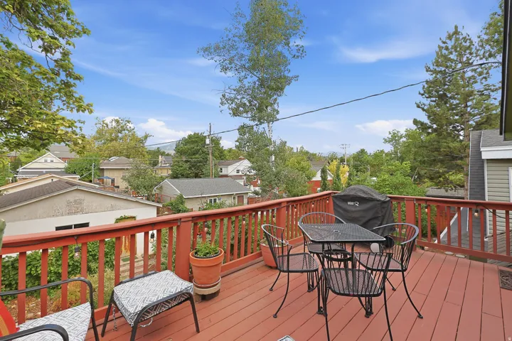 Spacious outdoor deck featuring red-toned wood flooring and railing