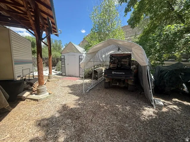 Outdoor covered area with wood-finish support beams and a wood chip ground cover