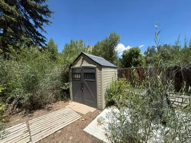Two-tone exterior storage shed with double doors and transom windows