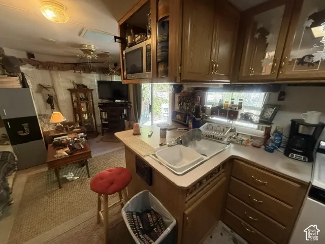 Kitchen with wood-finish cabinetry, integrated sink, and white countertops