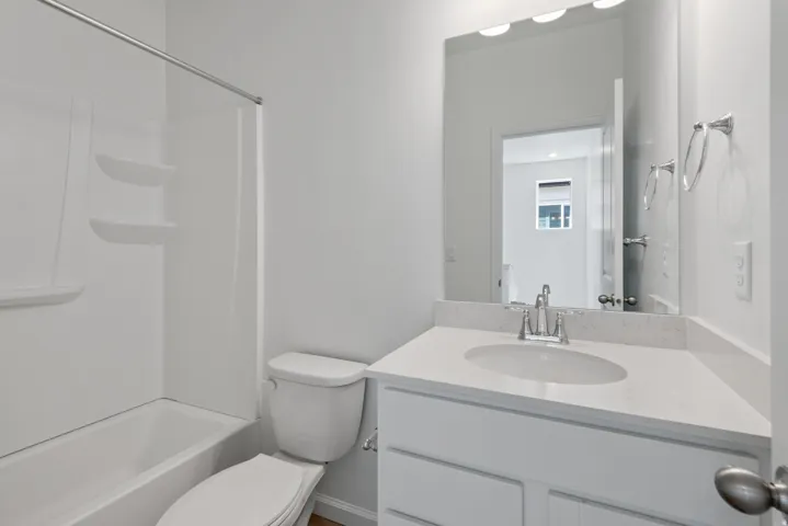 Bathroom featuring a white vanity with an undermount sink, a stone-finish countertop, and a chrome faucet