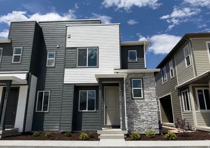 Contemporary architectural design featuring a multi-textured facade with horizontal siding and stacked stone accents