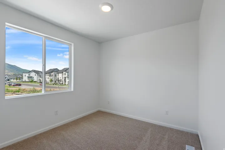 Room featuring light neutral wall paint, white trim, recessed ceiling light, carpet flooring, and a large window