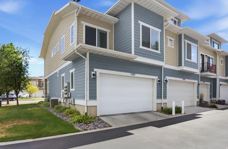 Townhome exterior featuring two-tone horizontal siding, white trim, and a two-car garage