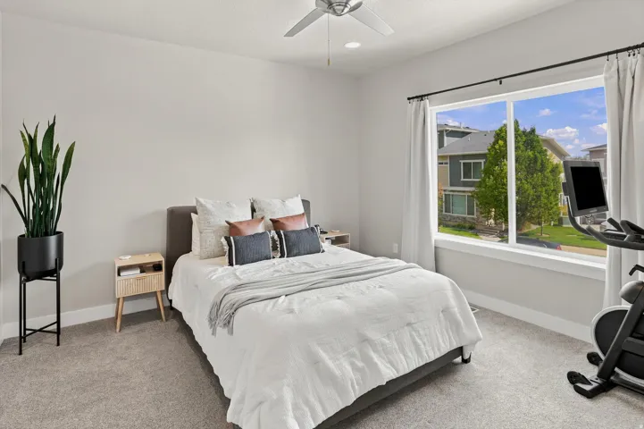 Bright interior space featuring a large window, soft gray carpeting, recessed lighting, and a ceiling fan