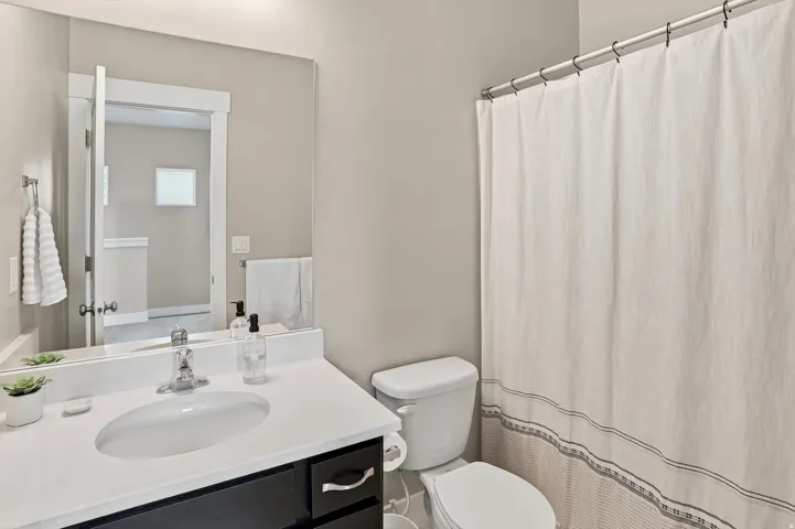 Bathroom featuring a single vanity with a white countertop, an undermount sink, and a chrome faucet
