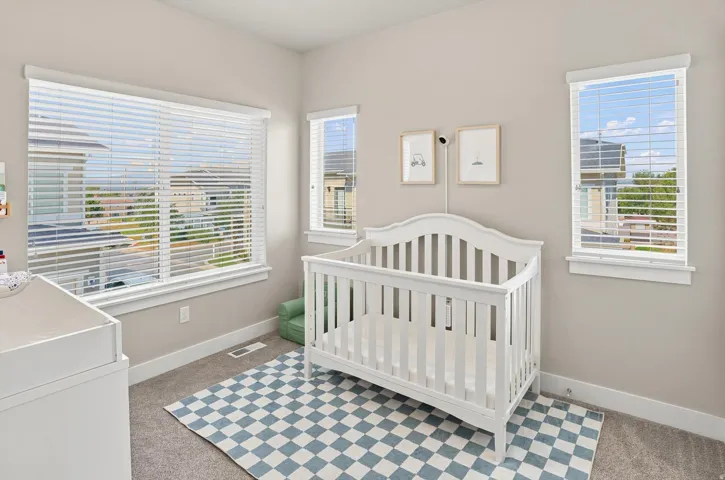 Carpeted interior room with neutral wall tones and white baseboards