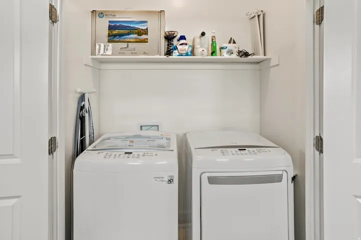 Dedicated laundry area featuring a built-in shelf, white walls, and paneled bifold doors