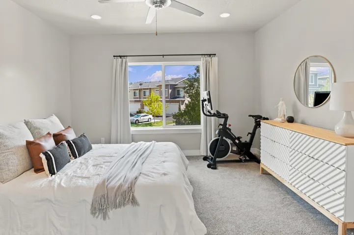 Bright room featuring a large window, recessed lighting, and a ceiling fan