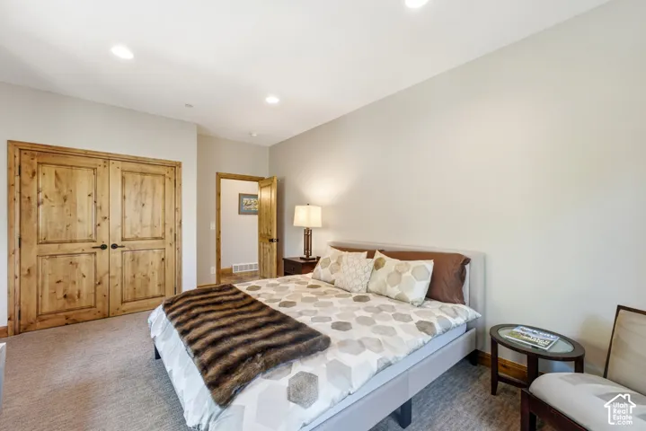 Room featuring warm-toned wood double doors, recessed lighting, and neutral wall tones