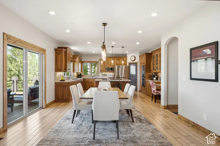 Open-concept living space featuring wood-finish flooring, recessed lighting, and a sliding glass door leading to an outdoor deck