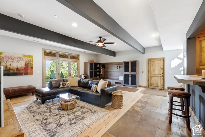 Spacious living area featuring exposed ceiling beams and recessed lighting