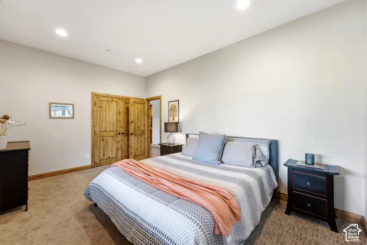 Recessed lighting illuminates this room featuring durable carpeting and light-toned walls