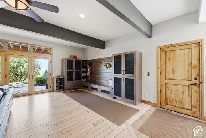 Light wood-finish flooring complemented by a rich wood-paneled built-in storage bench with coat hooks