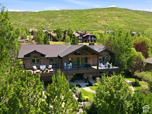 Elevated property with a expansive multi-level deck, dark shingle roofing, and warm-toned exterior siding