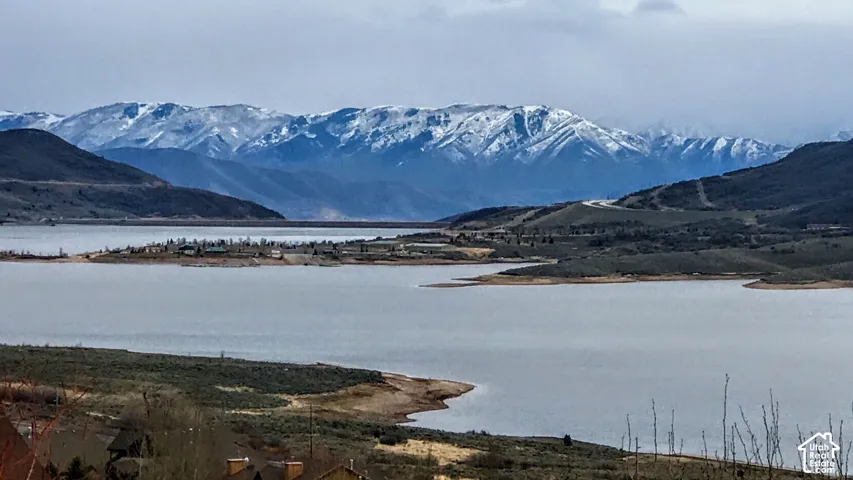 Expansive water body with surrounding natural terrain and distant snow-capped mountains