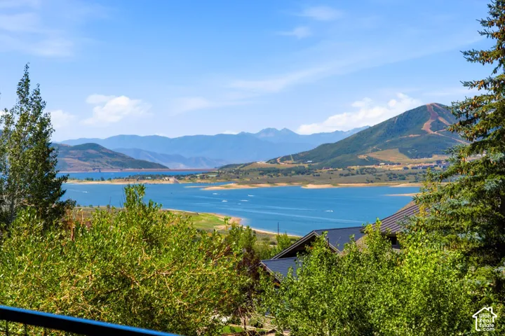 Expansive lake and mountain scenery featuring a large body of water, distant mountain ranges, and a sloped terrain with visible ski runs