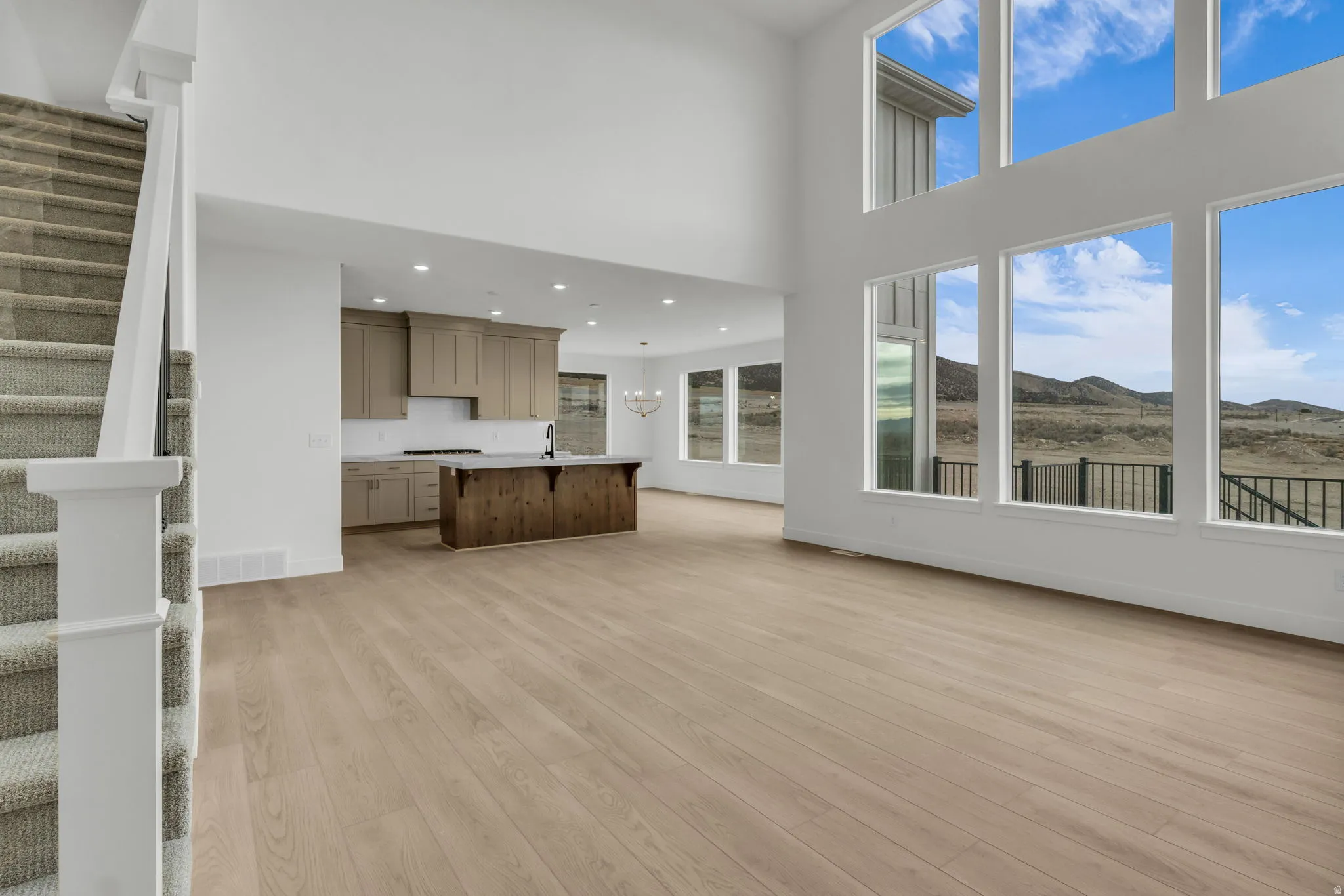 Two story open great room featuring high ceilings and custom expansive windows to look out to the generous back yard of the  .75 acre lot!