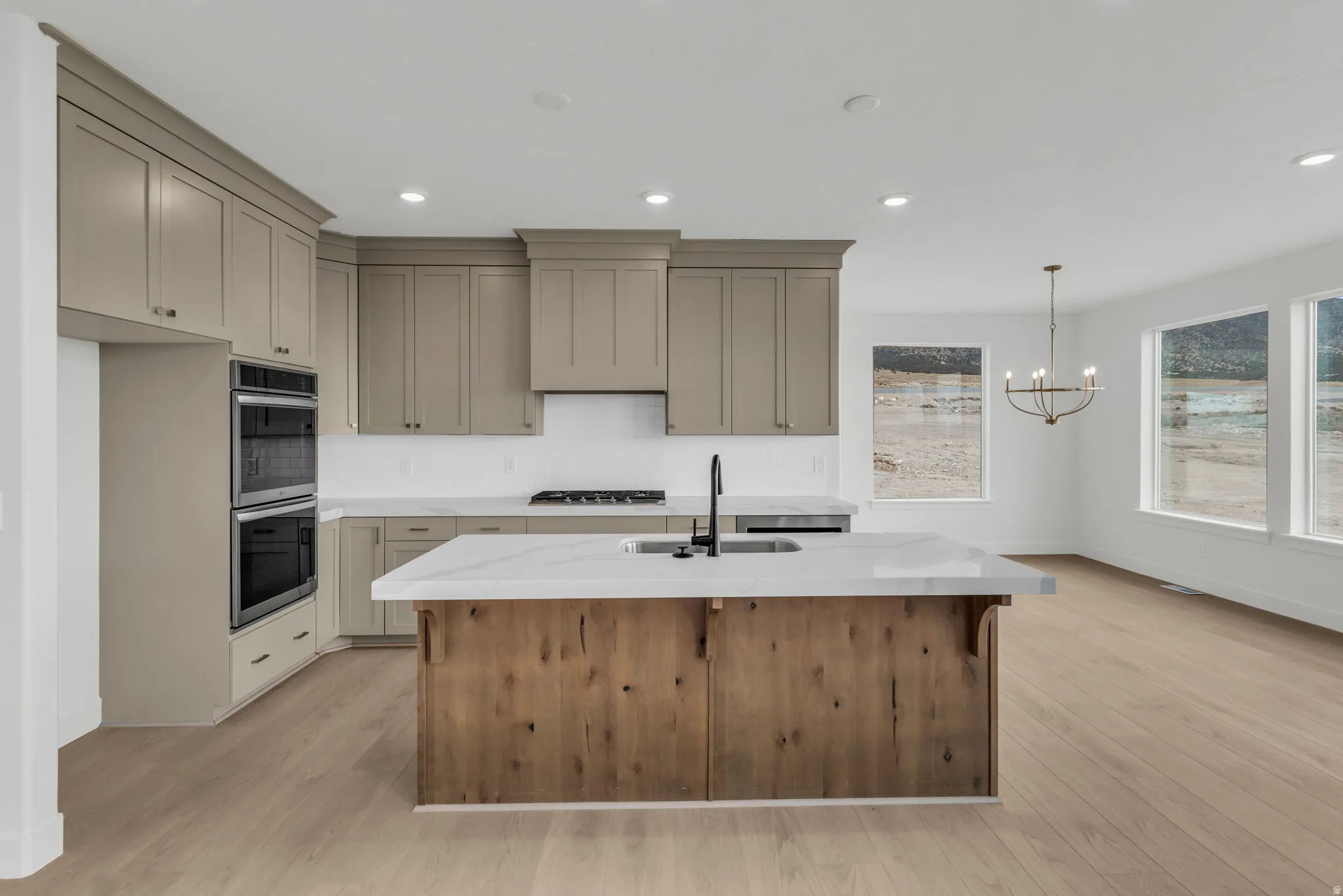 Beautiful wood full height cabinetry in the open kitchen featuring a central island and Quartz countertops, an undermount sink with matte black hardware and faucet.