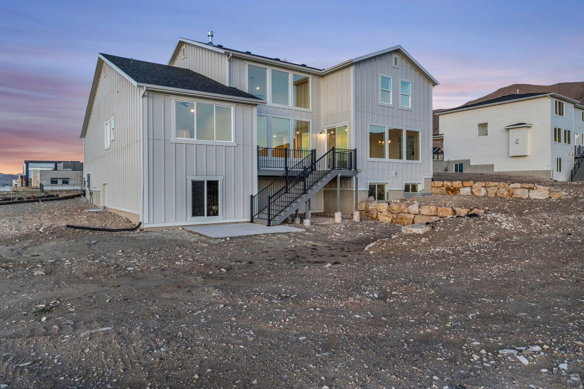 Exterior view from southwest corner of our beautiful custom farmhouse style home, with rock terracing.