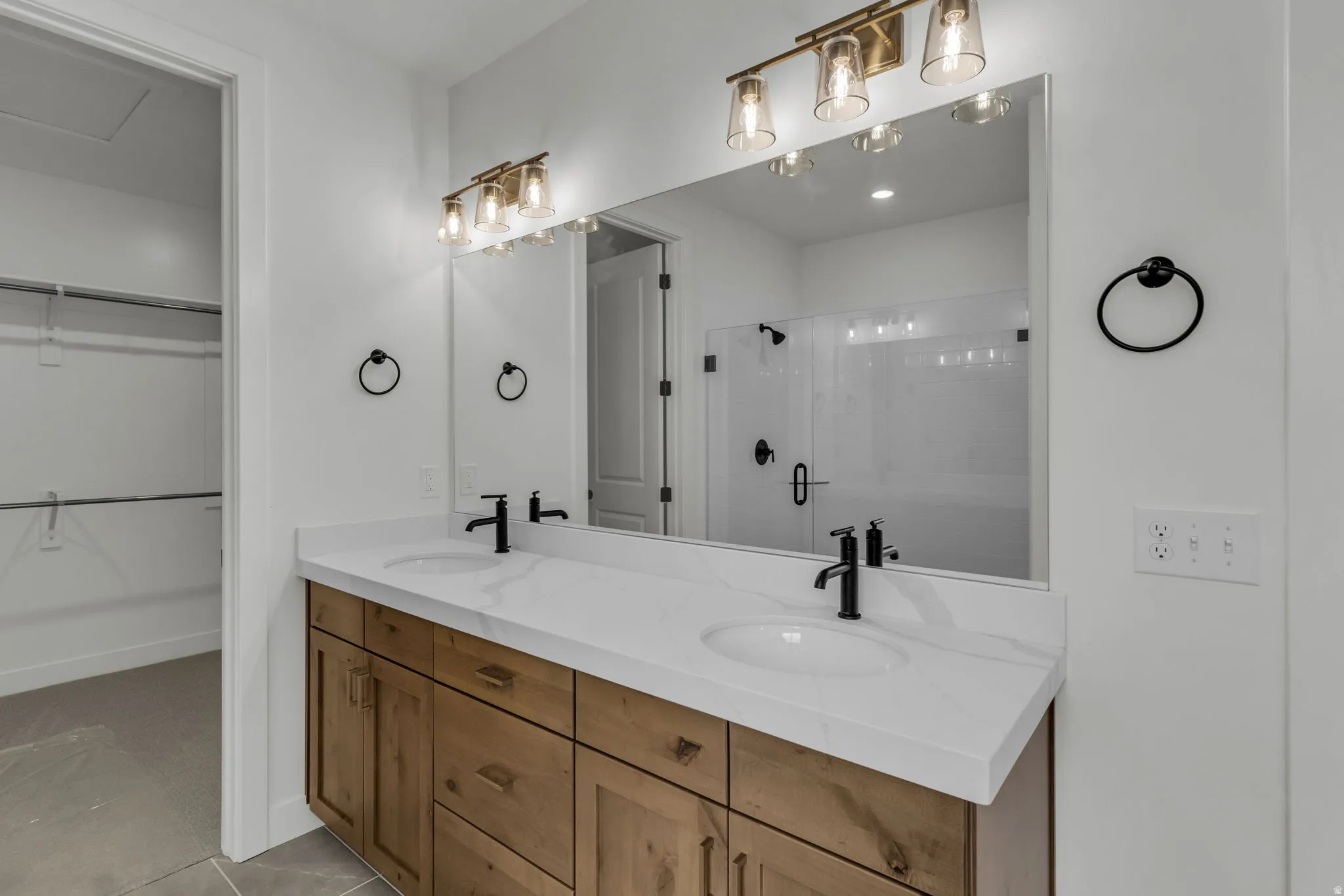 Primary bathroom with double vanity and large oversized mirror.