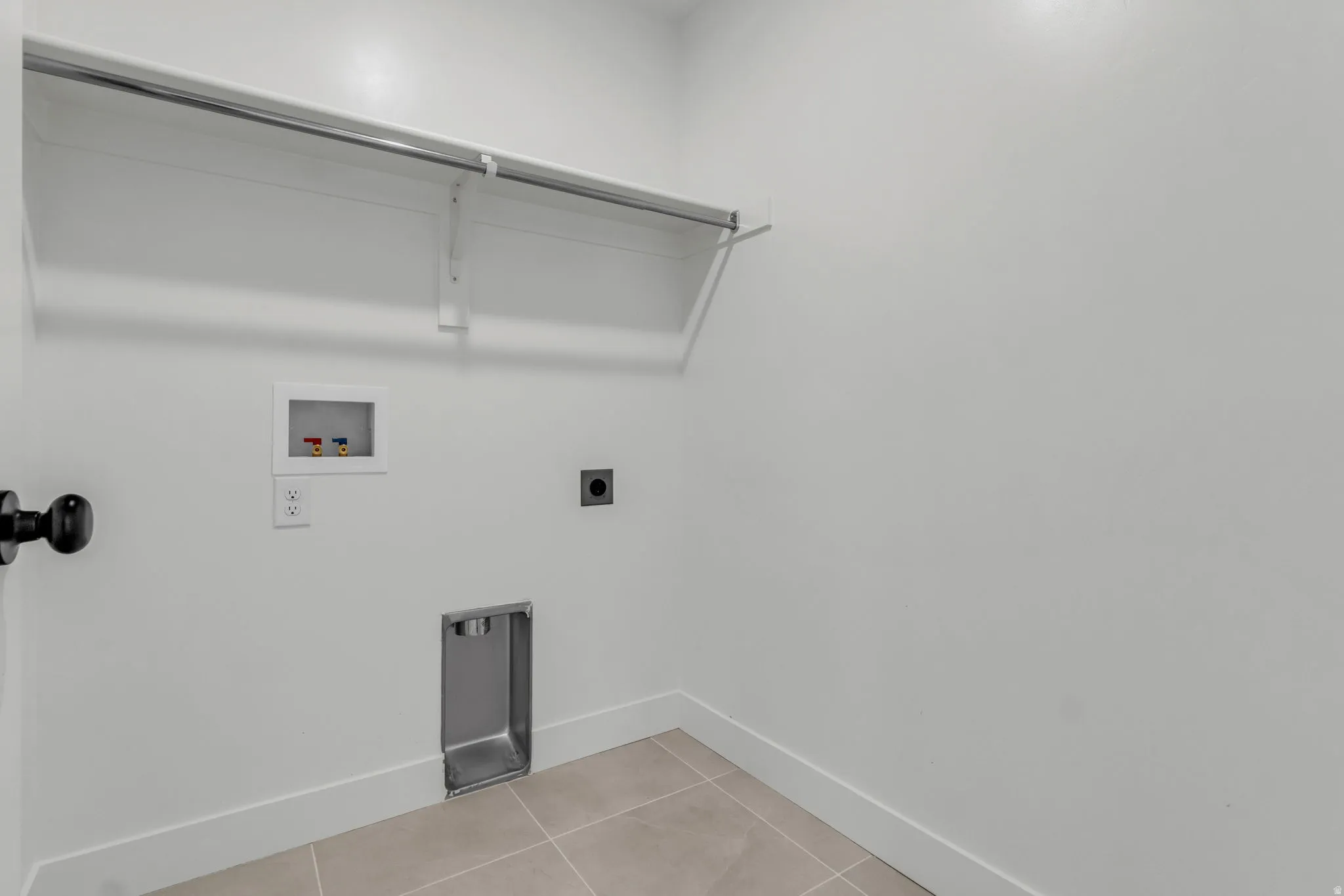 Spacious laundry room with custom tile flooring.
