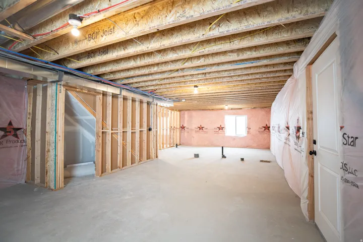 Unfinished basement with potential for large family/game room with full bathroom, two bedrooms, plumbed for kitchen and washer.