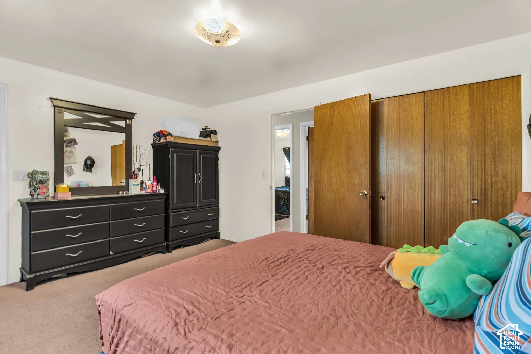 Bedroom featuring wood-finish closet doors, neutral wall paint, and a textured ceiling light fixture