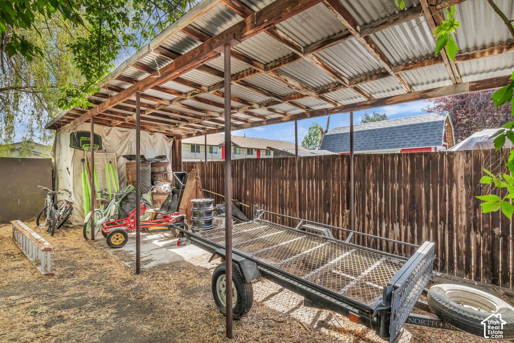 Expansive covered outdoor structure featuring a corrugated metal roof and exposed wood framing