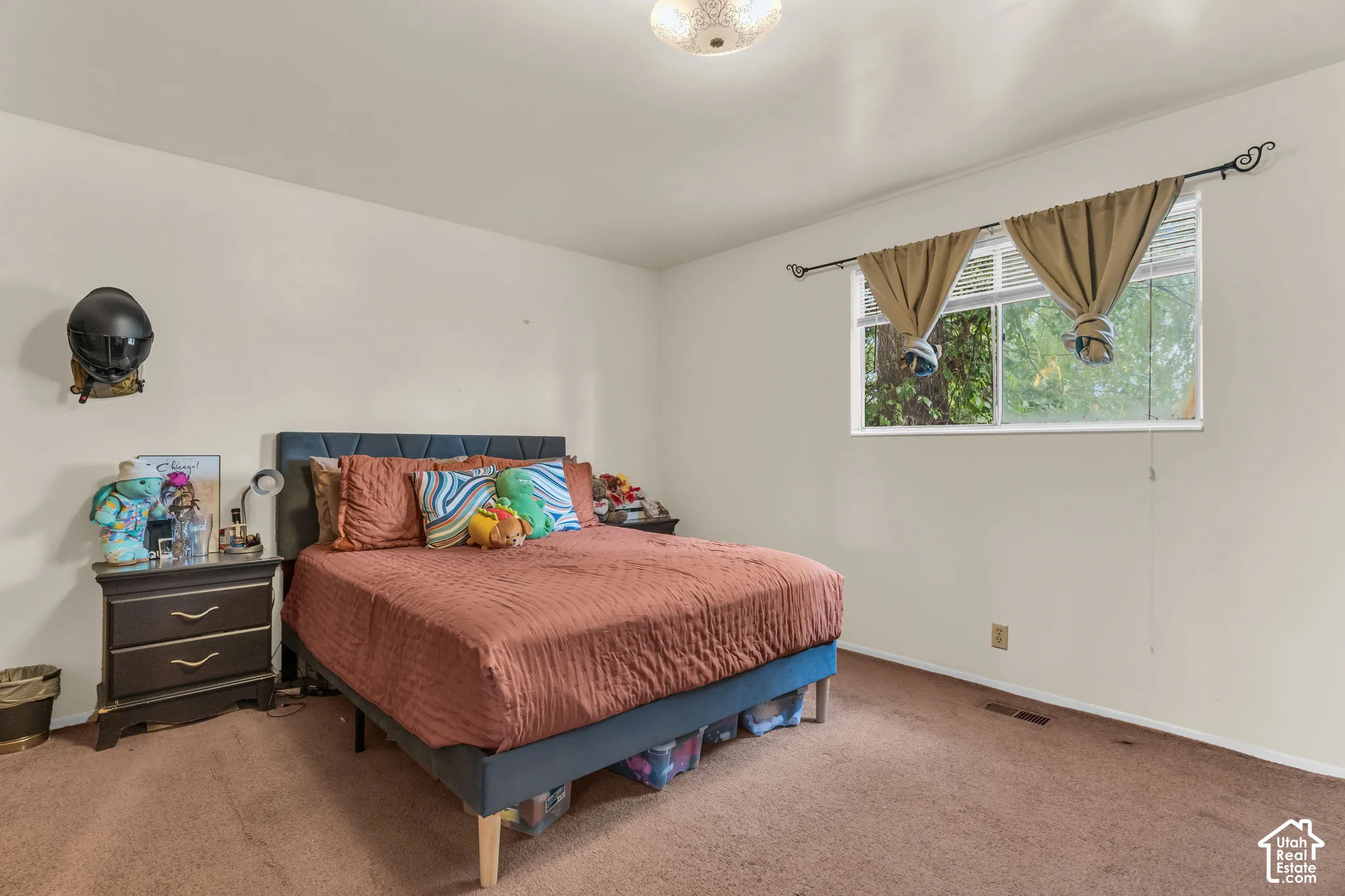 Carpeted bedroom featuring neutral walls and a window with horizontal blinds
