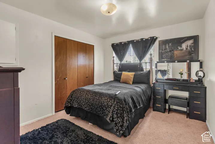 Bedroom featuring wood-finish bi-fold closet doors, a single window, and a flush mount ceiling light