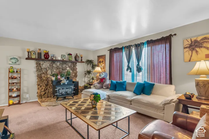 Living area featuring a stone fireplace with a wood-burning stove insert