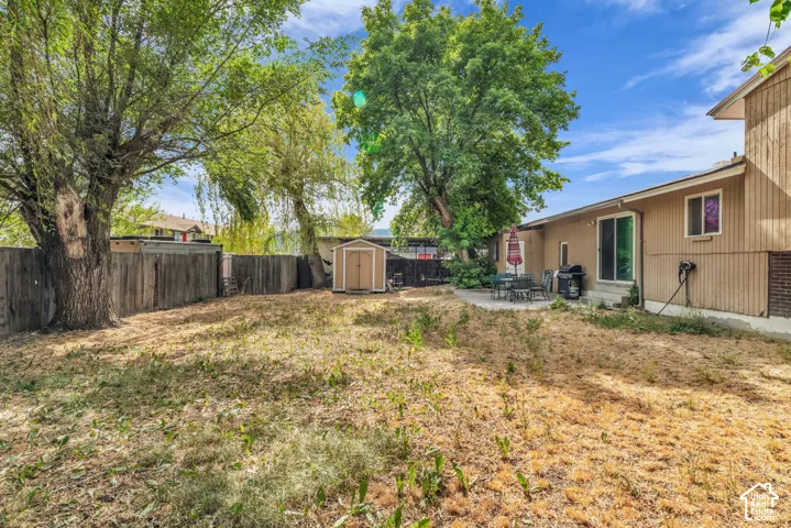 Spacious backyard featuring mature trees and a wood privacy fence