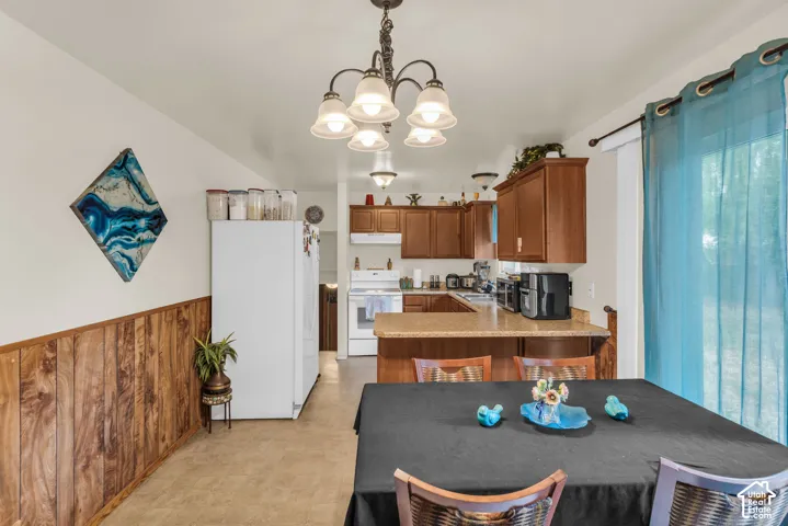 Kitchen and dining area featuring wood-finish cabinetry, a built-in kitchen island with countertop, and wood-finish wall paneling