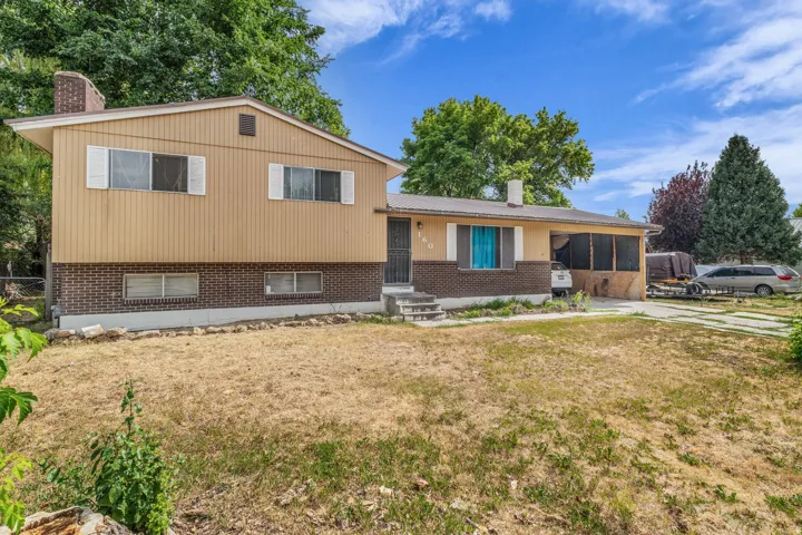 Split-level residence featuring a brick and siding exterior, front lawn, and concrete driveway