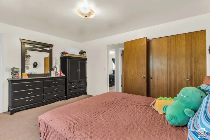 Bedroom featuring wood-finish closet doors, neutral wall paint, and a textured ceiling light fixture