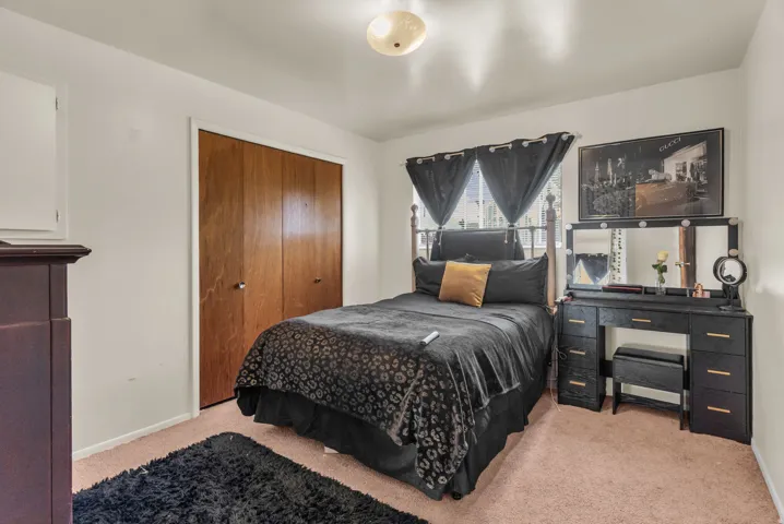 Bedroom featuring wood-finish bi-fold closet doors, a single window, and a flush mount ceiling light